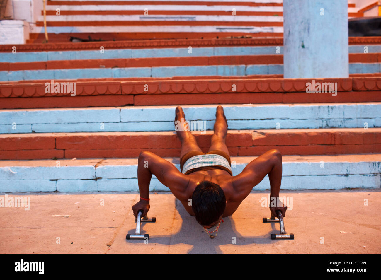 In Varanasi finden jeden Morgen unter den Menschen im heiligen Ganges Baden Sie Menschen Yoga praktizieren und Wahrnehmung in der Öffentlichkeit. Stockfoto