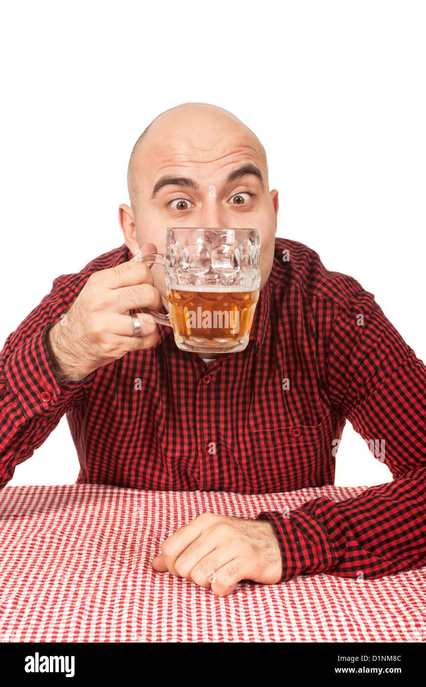 Junge Erwachsene glatzköpfiger Mann trinkt Bier aus einem Krug Stockfoto