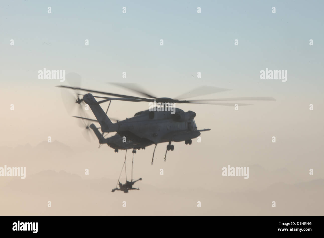 Zwei US-Marinekorps CH-53E Super Hengste mit Marine schwere Hubschrauber Geschwader (HMH) 361, Marine Aircraft Gruppe 16, 3rd Marine Aircraft Wing (vorwärts), heben Sie extern M777 Haubitzen über Provinz Helmand, Afghanistan, 29. Dezember 2012. HMH-361 zur Verfügung gestellt Stockfoto