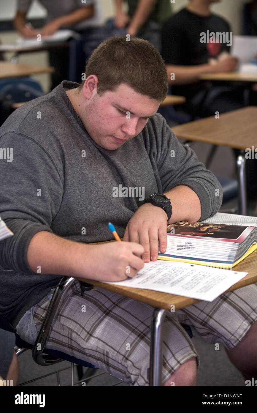 California High School Student Papierarbeiten eine zugewiesene während einer Lesung Übung mit eine literarische Anthologie. Stockfoto