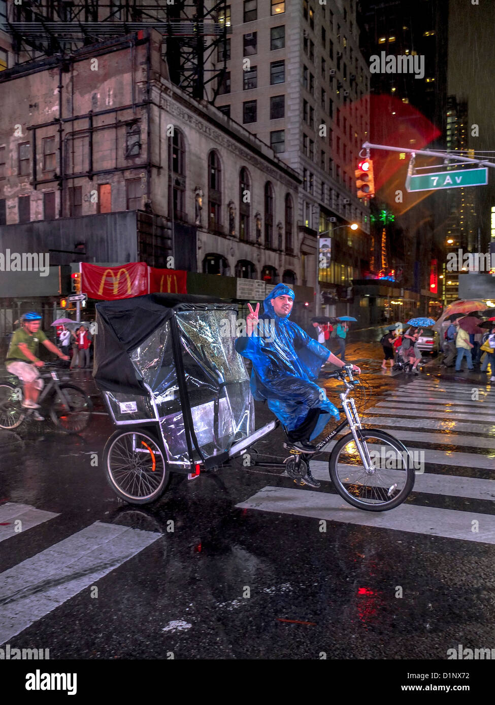 Raincoated Hispanic Rikscha Taxi-Fahrer winkt ein schlägt beim Reiten hinunter Broadway Times Square, New York City. Stockfoto