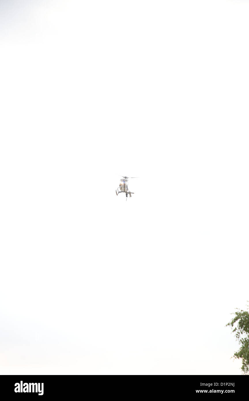 Hubschrauber fliegt hoch in einem wolkigen Himmel Stockfoto