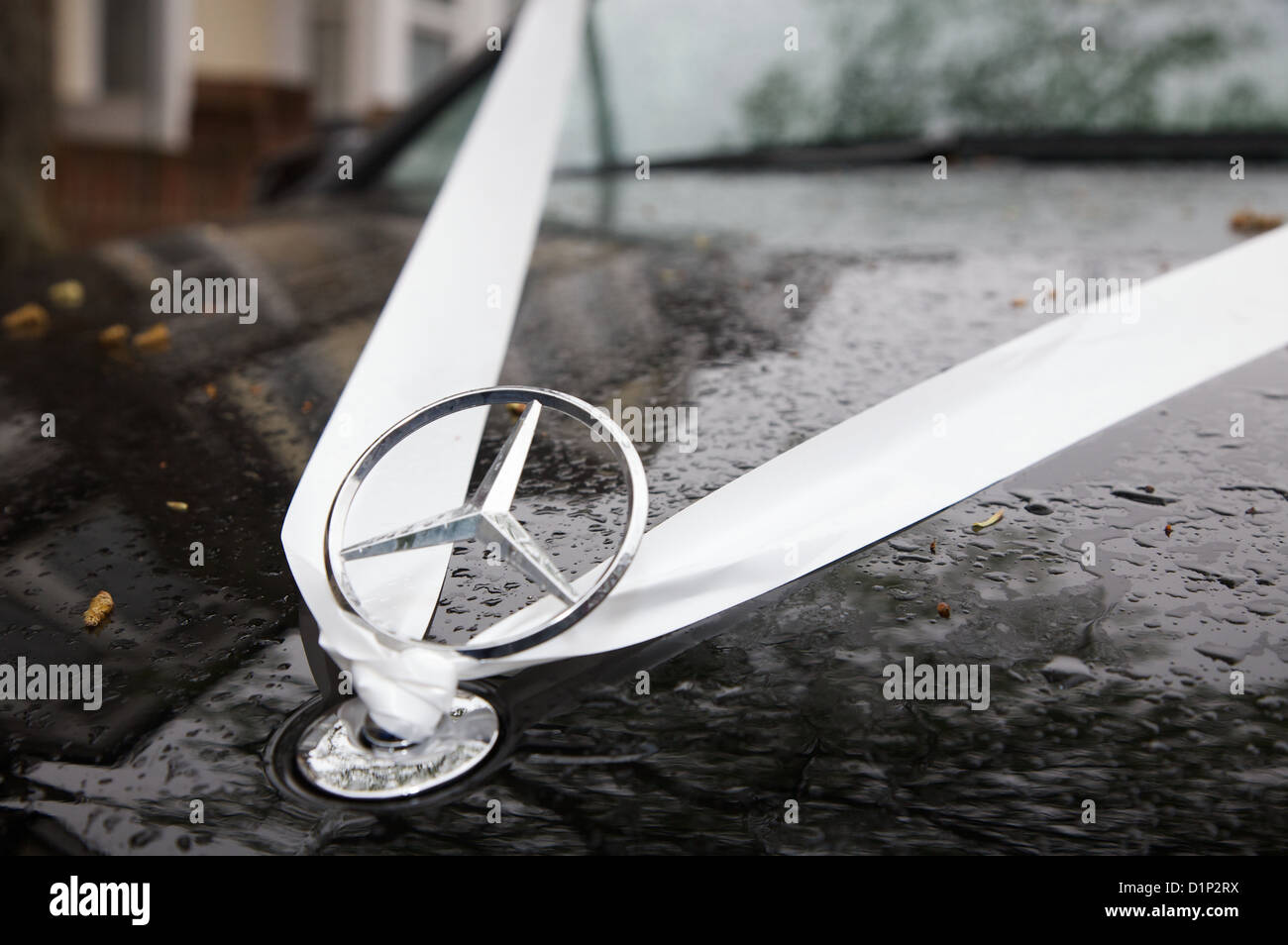Mercedes Motorhaube mit weißen Hochzeit Band an einem regnerischen Tag Stockfoto