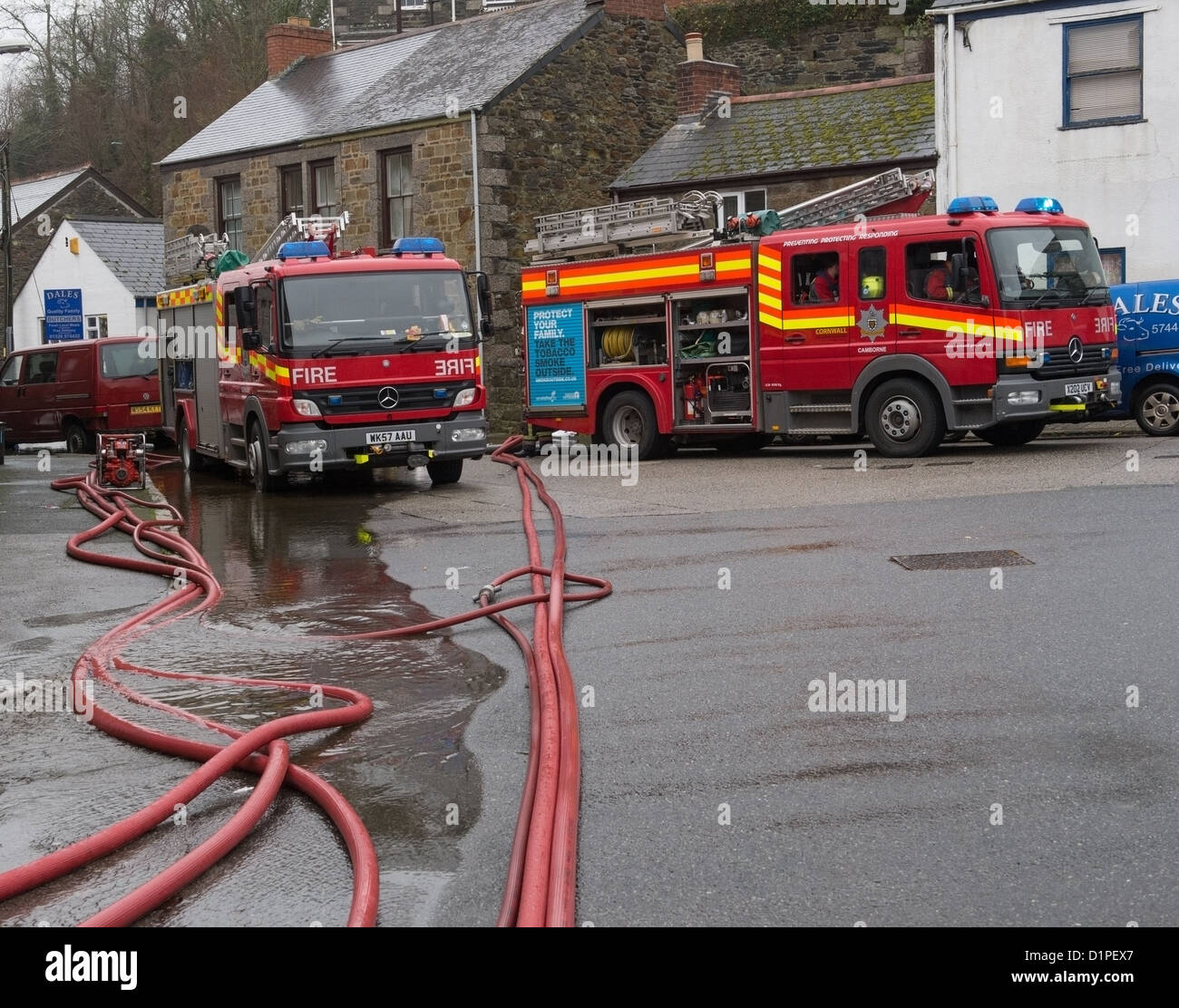 Helston Flut, Feuerwehrfahrzeuge und Schläuche manipuliert, um Hochwasser aus dem St. Johns Helston entfernen Stockfoto