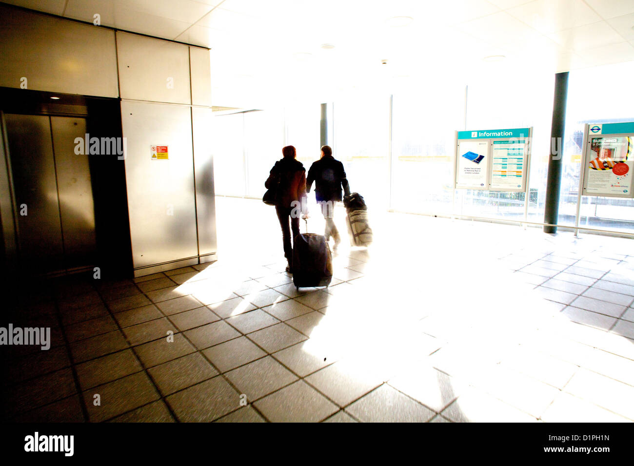 zwei (2) Reisende im Urlaub ziehen Wagen Fällen an der London City Airport, London England, UK Stockfoto