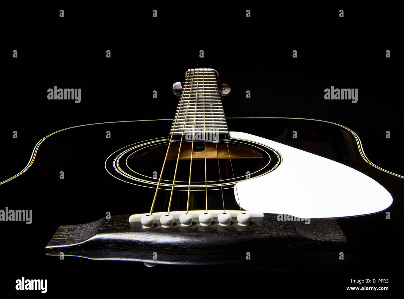 Schwarze Gitarre - eine klassische schwarze Stahlzeichenketteguitarre mit weißen Akzenten. Stockfoto