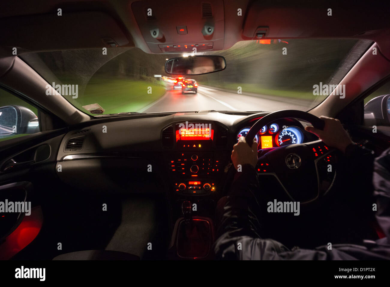 Fahrer-Perspektive fahren Sie schnell in Richtung zwei Autos in der Nacht auf der Landstraße. Stockfoto