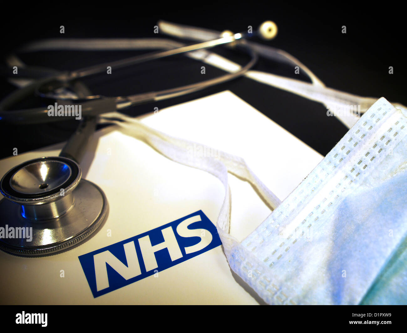 Stillleben mit Mundschutz und Stethoskop mit NHS-logo Stockfoto