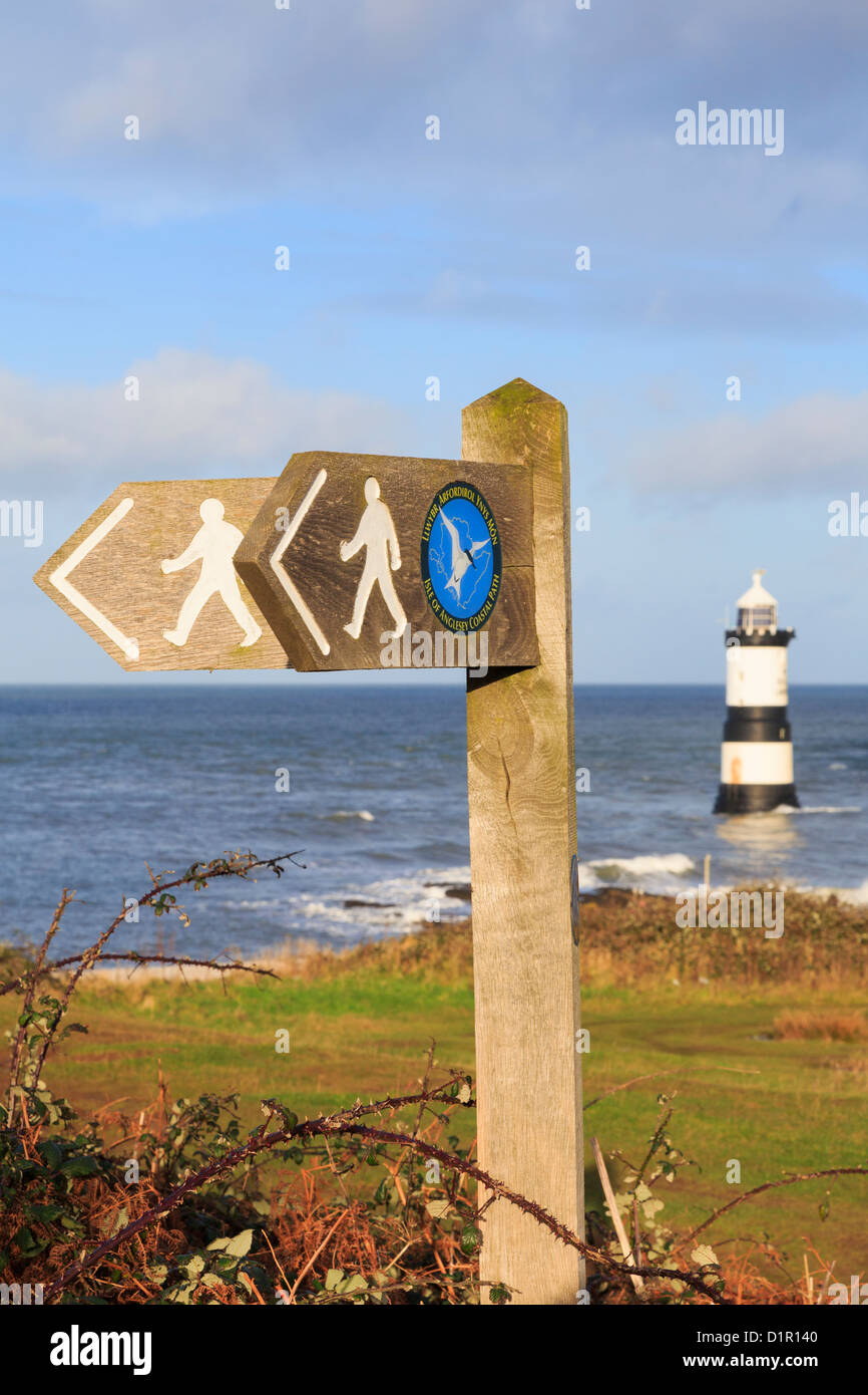 Isle of Anglesey Küstenweg und Wales Coast Path Wegweiser mit Trwyn Penmon Leuchtturm (Du) aus Küste darüber hinaus. Penmon Point North Wales UK Stockfoto