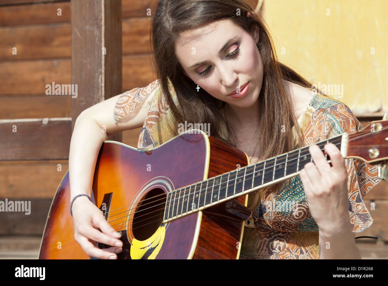 junge Frau Palying Gitarre Stockfoto