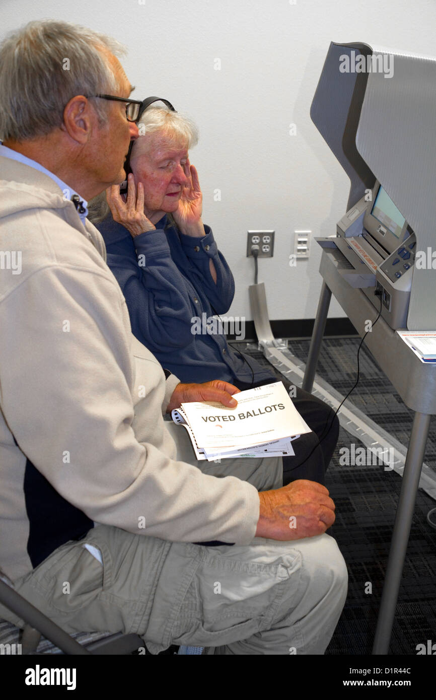 Blinde und Sehbehinderte Frau mit einem Kopfhörer für voting Hilfe in einem Wahllokal in Boise, Idaho, USA. Stockfoto