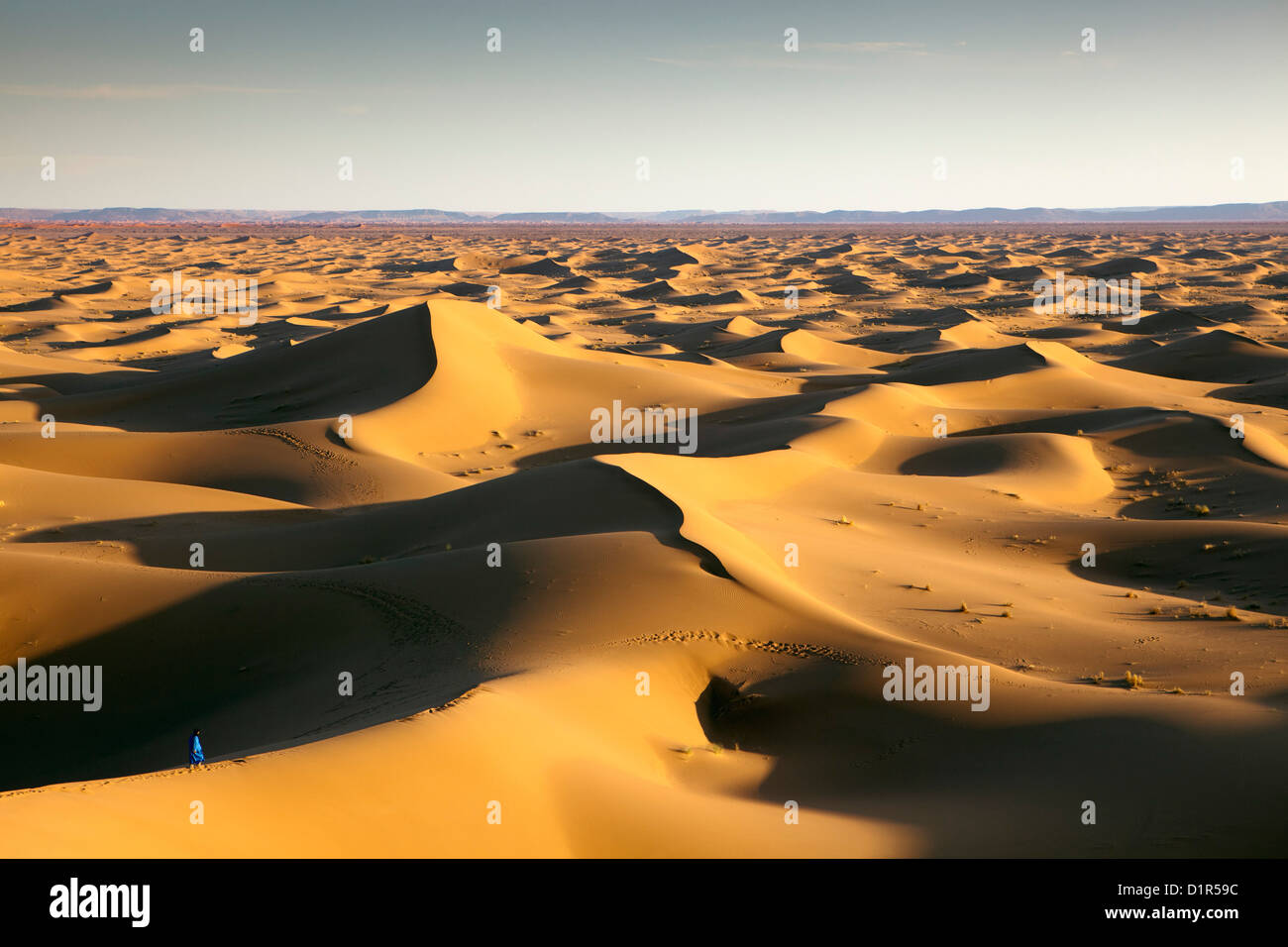 Marokko, M' Hamid, Erg Chigaga Dünen. Wüste Sahara. Lokalen Berber Mann auf Sanddüne, Hintergrund Touristenlager, Biwak. Stockfoto