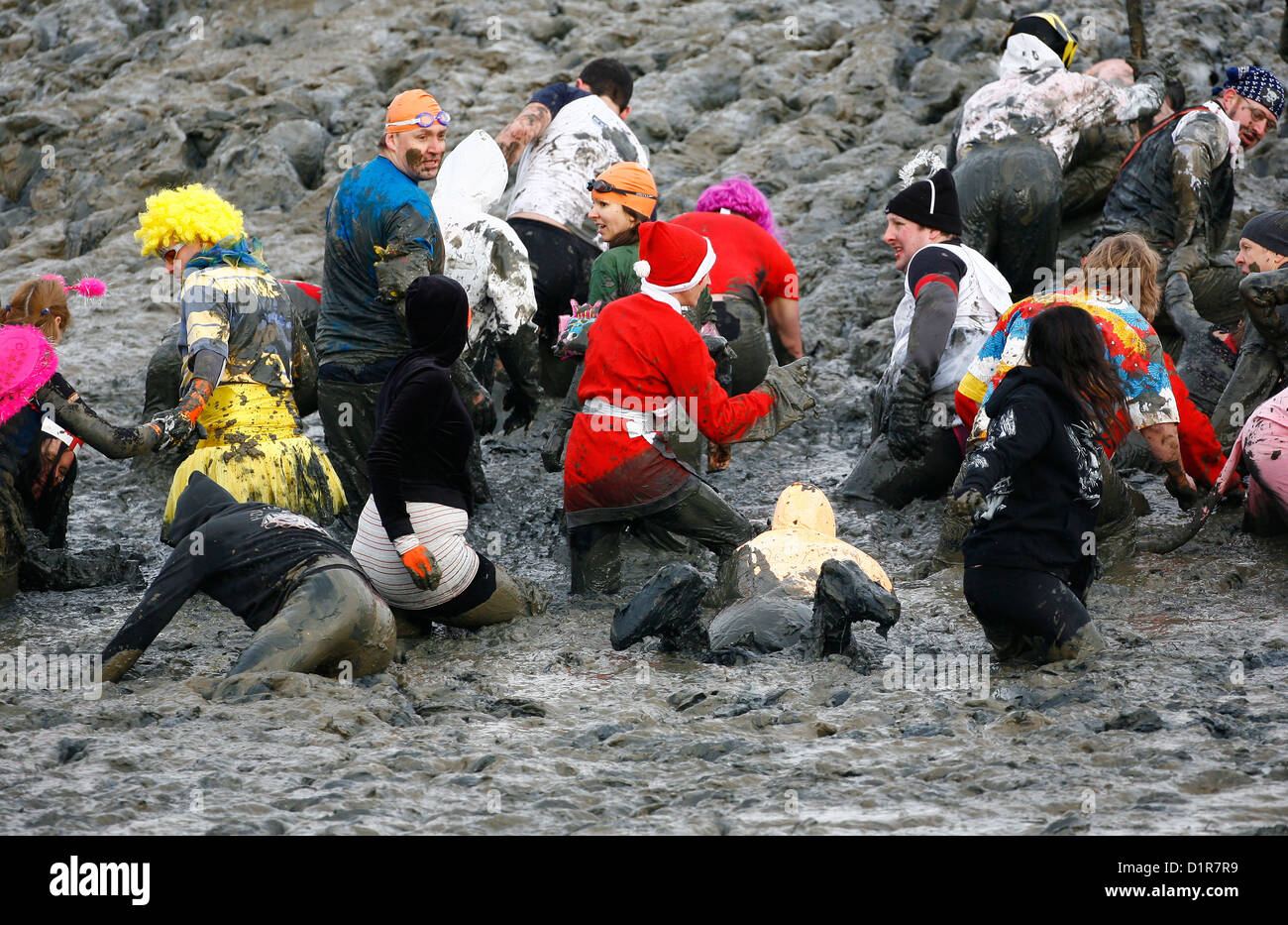 Konkurrenz-Kampf durch den dicken Dreck während der jährlichen Maldon Mud Race in Maldon in Essex. Stockfoto