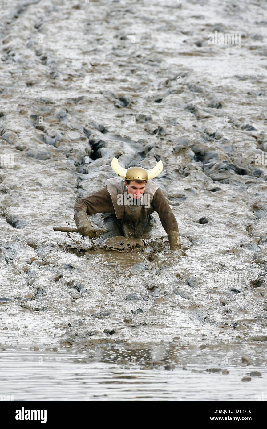 Konkurrenz-Kampf durch den dicken Dreck während der jährlichen Maldon Mud Race in Maldon in Essex. Stockfoto