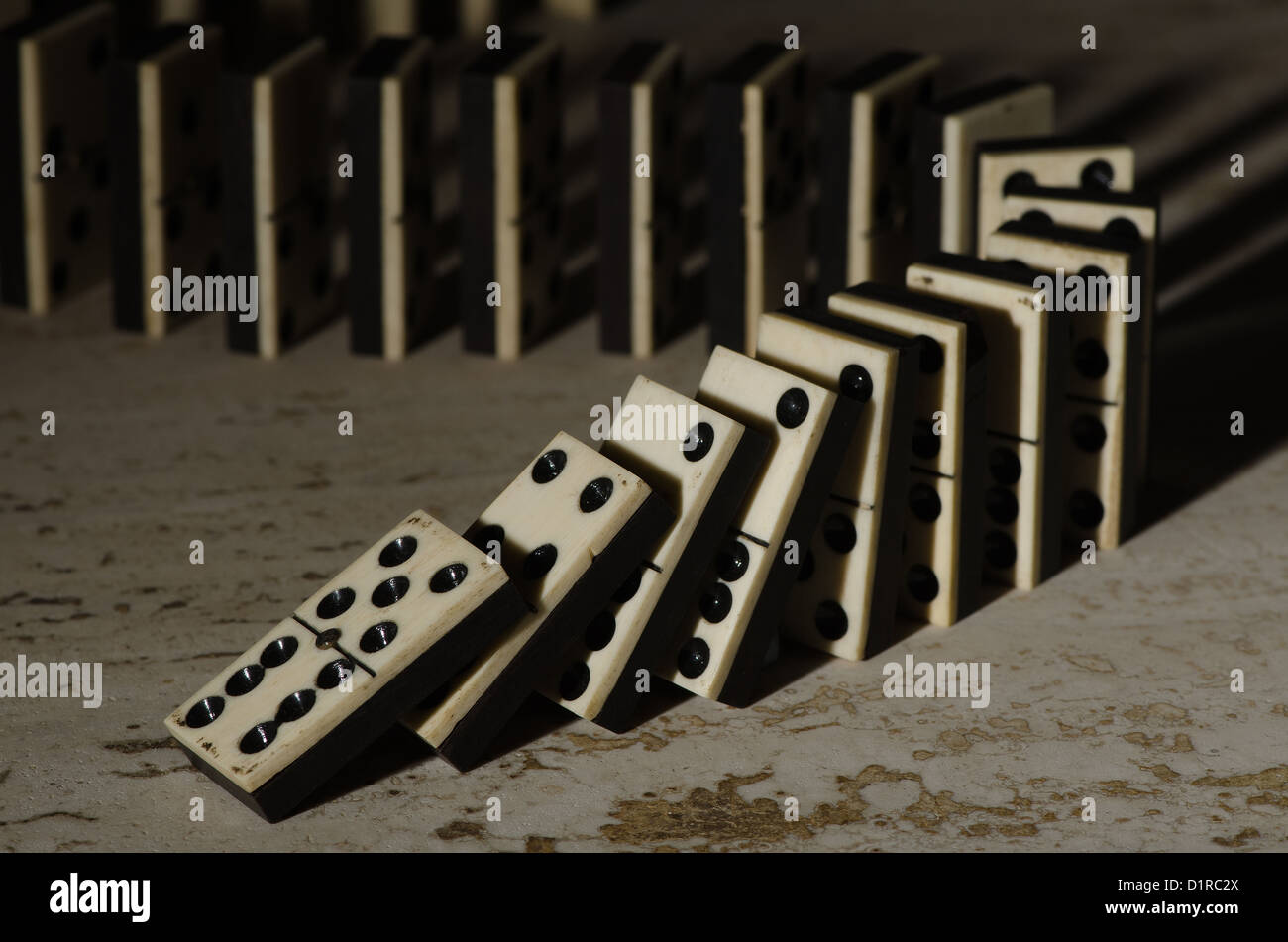 Reihen von aufgereiht altes Elfenbein und Ebenholz Bronze angehefteten stehende Domino blockiert Stücke auf weißem Tan Travertin-Marmor Stockfoto