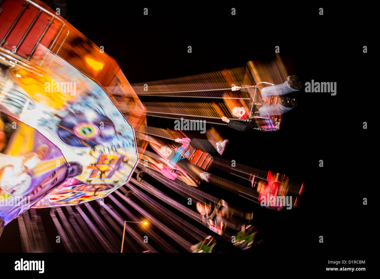 Kinder auf einem Jahrmarkt Schaukel Stuhl fahren auf einem Rummelplatz, Aberystwyth, Wales UK November 2012 Stockfoto