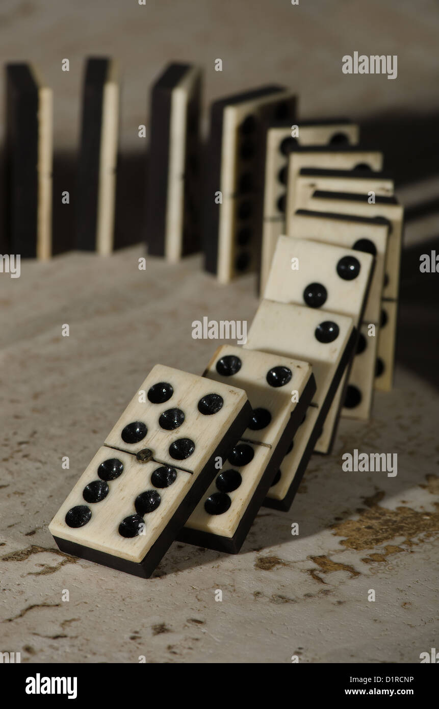 Reihen von aufgereiht altes Elfenbein und Ebenholz Bronze angehefteten stehende Domino blockiert Stücke auf weißem Tan Travertin-Marmor Stockfoto