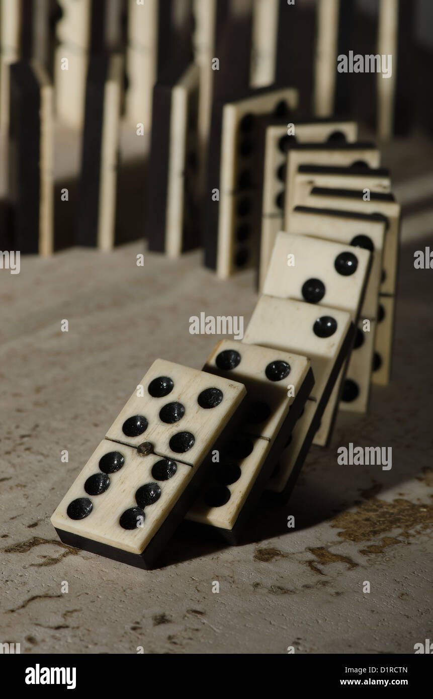 Reihen von aufgereiht altes Elfenbein und Ebenholz Bronze angehefteten stehende Domino blockiert Stücke auf weißem Tan Travertin-Marmor Stockfoto