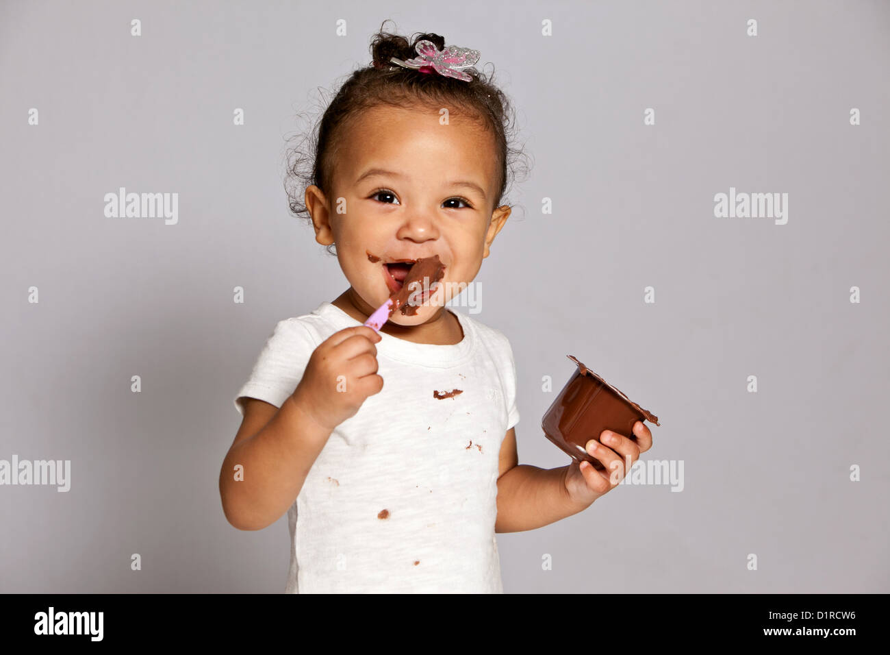 Niedliche kleine Mädchen, Kleinkind, ein Chaos essen Schokolade Wüste. Stockfoto