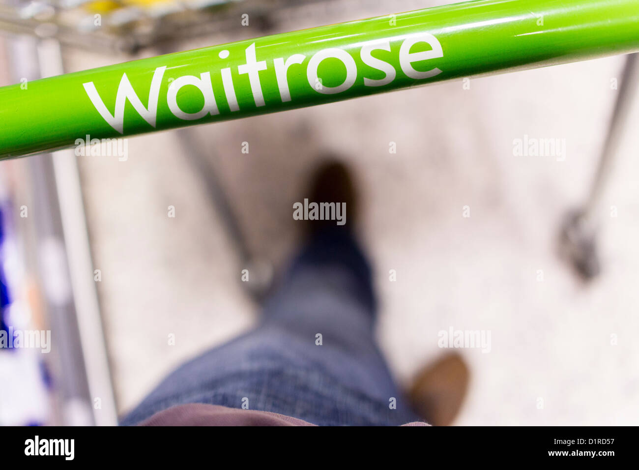 Ein Kunde ein Waitrose Einkaufswagen schieben. Stockfoto