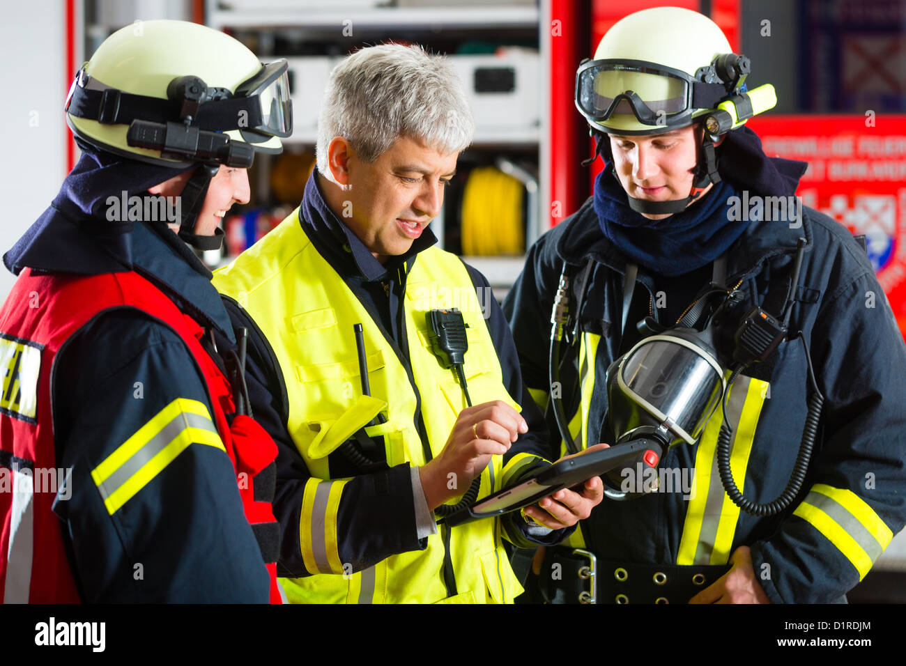 Feuerwehr - Einsatzleiter gibt Anweisungen, benutzte er die Tablet-Computer die Bereitstellung planen Stockfoto