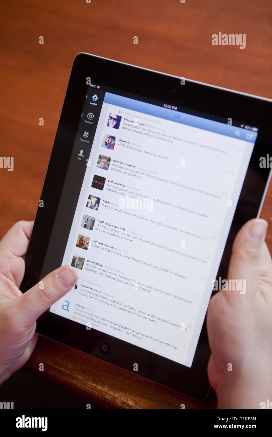 Eine Frau benutzt die Twitter-app auf einem iPad 4 Tablettcomputer. Stockfoto