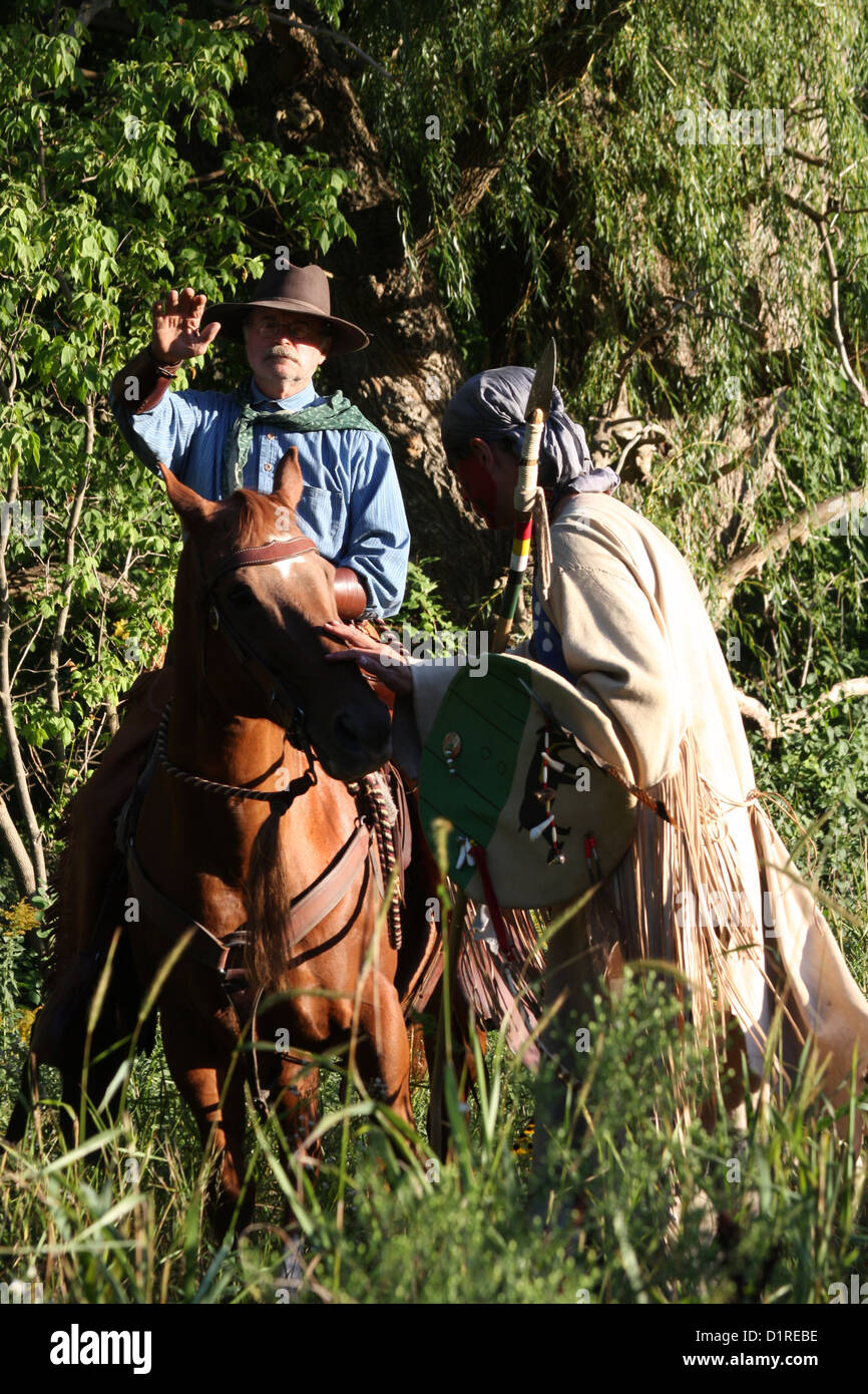 Ein Native American Indian Mann treffen einen Cowboy im Wald Stockfoto