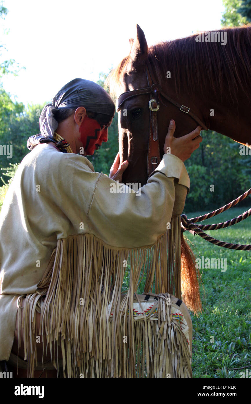 Ein Native American Indian Mann mit roter Bemalung Gruß sein Pferd. Stockfoto