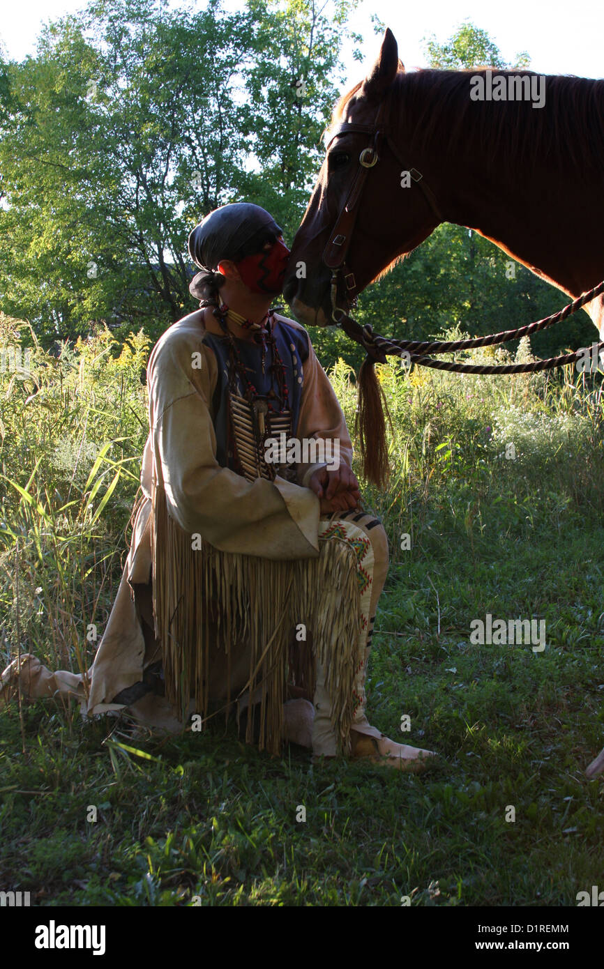 Ein Native American Indian Mann mit roter Bemalung Gruß sein Pferd. Stockfoto