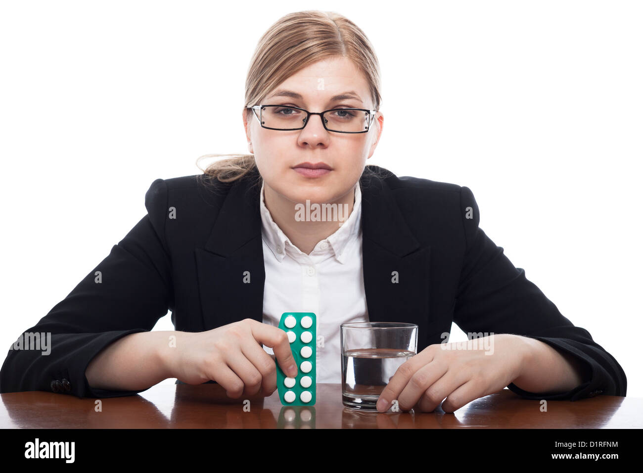 Ernsthafte Business-Frau mit Pillen und ein Glas Wasser, isoliert auf weißem Hintergrund. Stockfoto