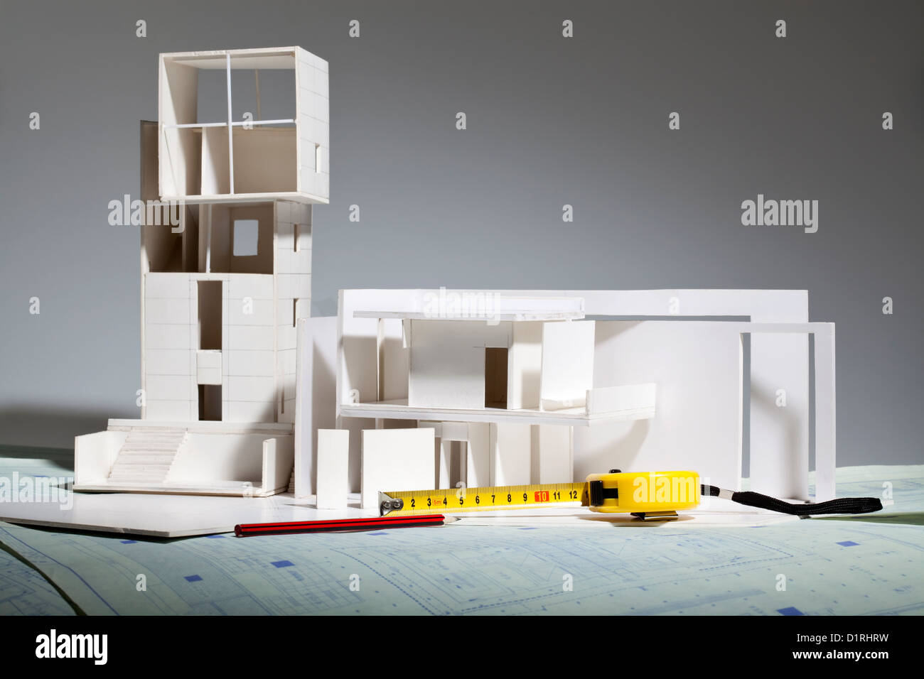 Architekturmodell und andere Büromaterial auf Blaupause Stockfoto