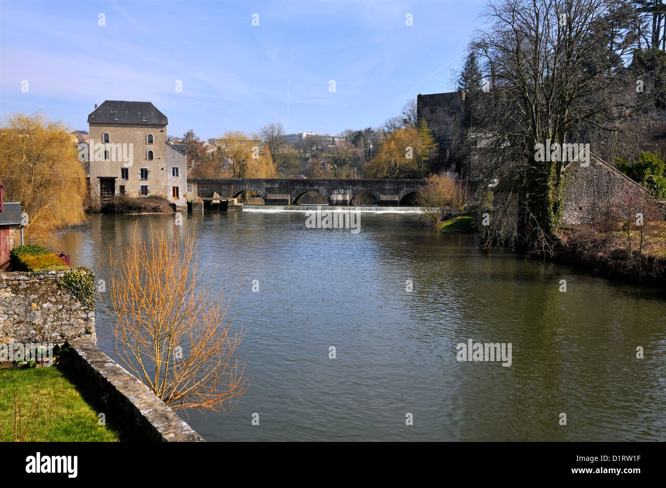 Der Fluss Sarthe am Fresnay in Frankreich mit kleinem Wasserfall und Gebäude im Hintergrund Stockfoto