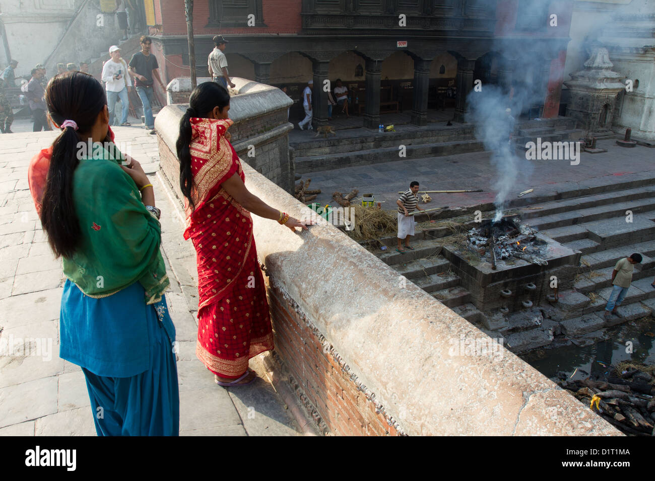 Zwei Frauen beobachten die brennenden Ghats in Pashupatinath Tempel auf den Bagmati Fluss Kathmandu Nepal Asien Stockfoto