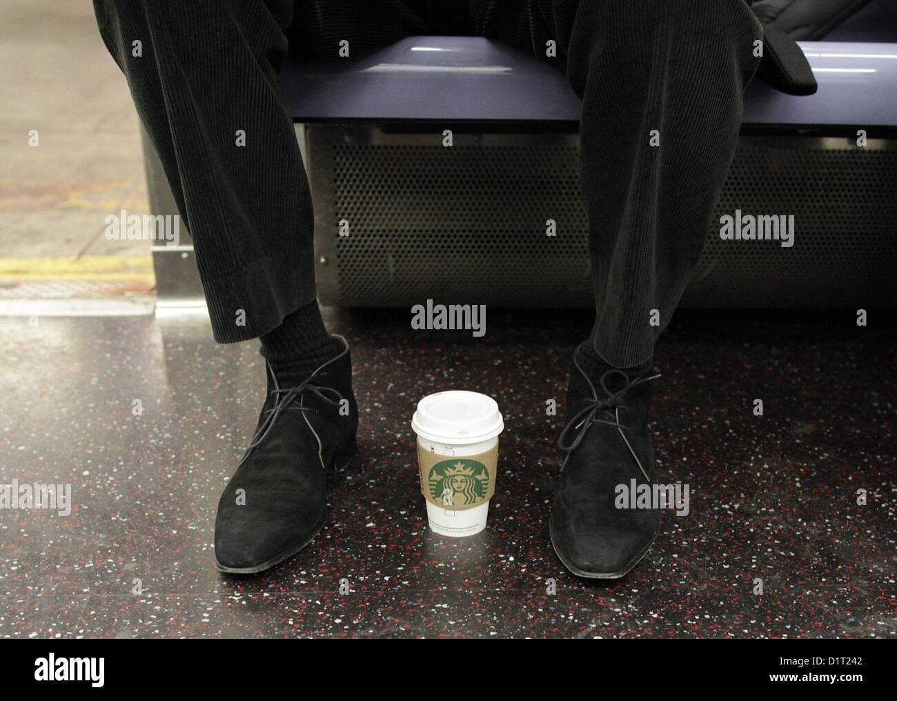 Starbucks Kaffee sitzt zwischen einem Passagiere Schuhe beim Gehen auf der MTA in Manhattan New York City New York USA arbeiten Stockfoto