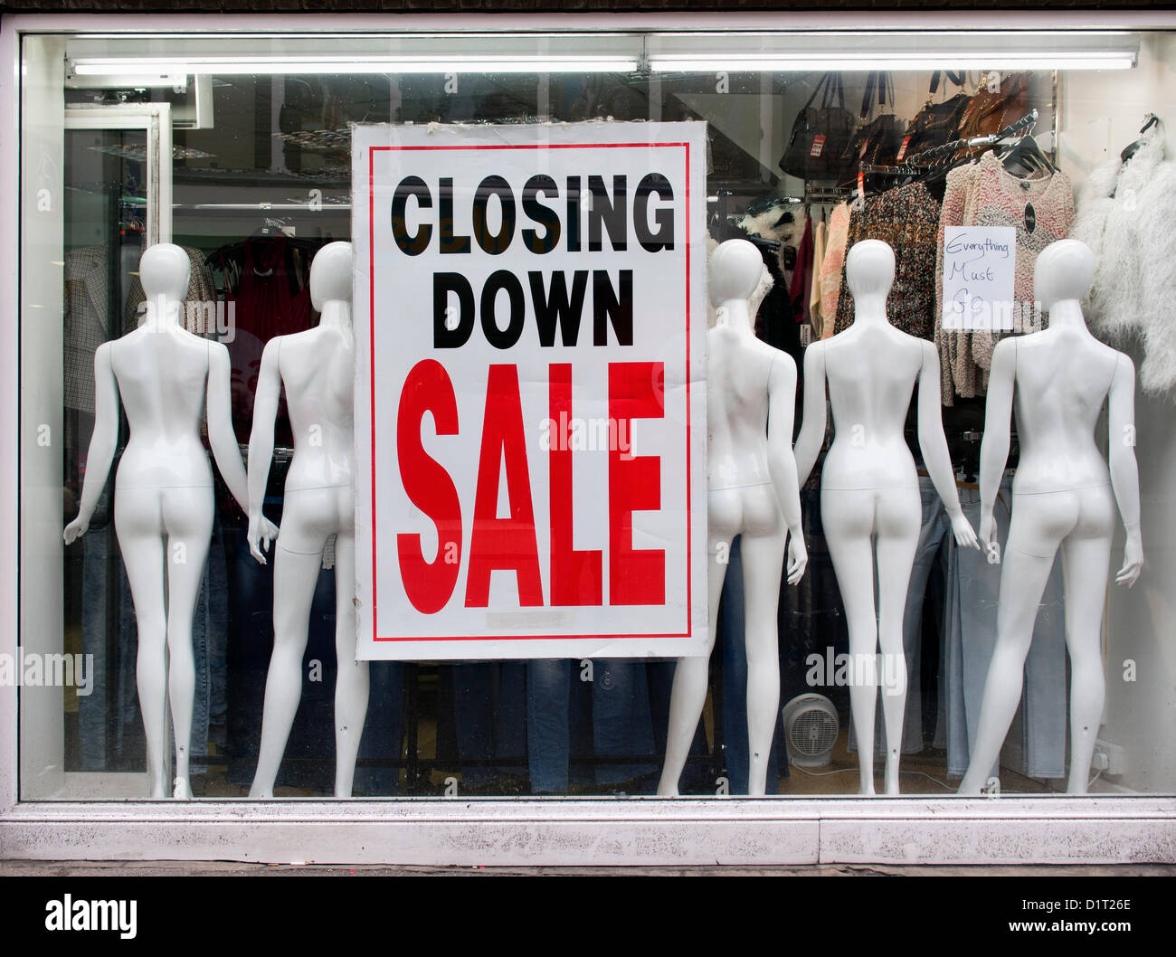 Ein Zeichen der Zeit: Schließung Verkauf unterzeichnen in einem Schaufenster in Oxford High Street mit einer bizarren Darstellung der Puppen. Stockfoto