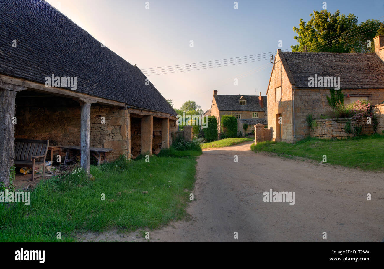 Alte traditionelle englische Farm bei Sonnenuntergang mit Warenkorb Schuppen und Bauernhaus. Stockfoto