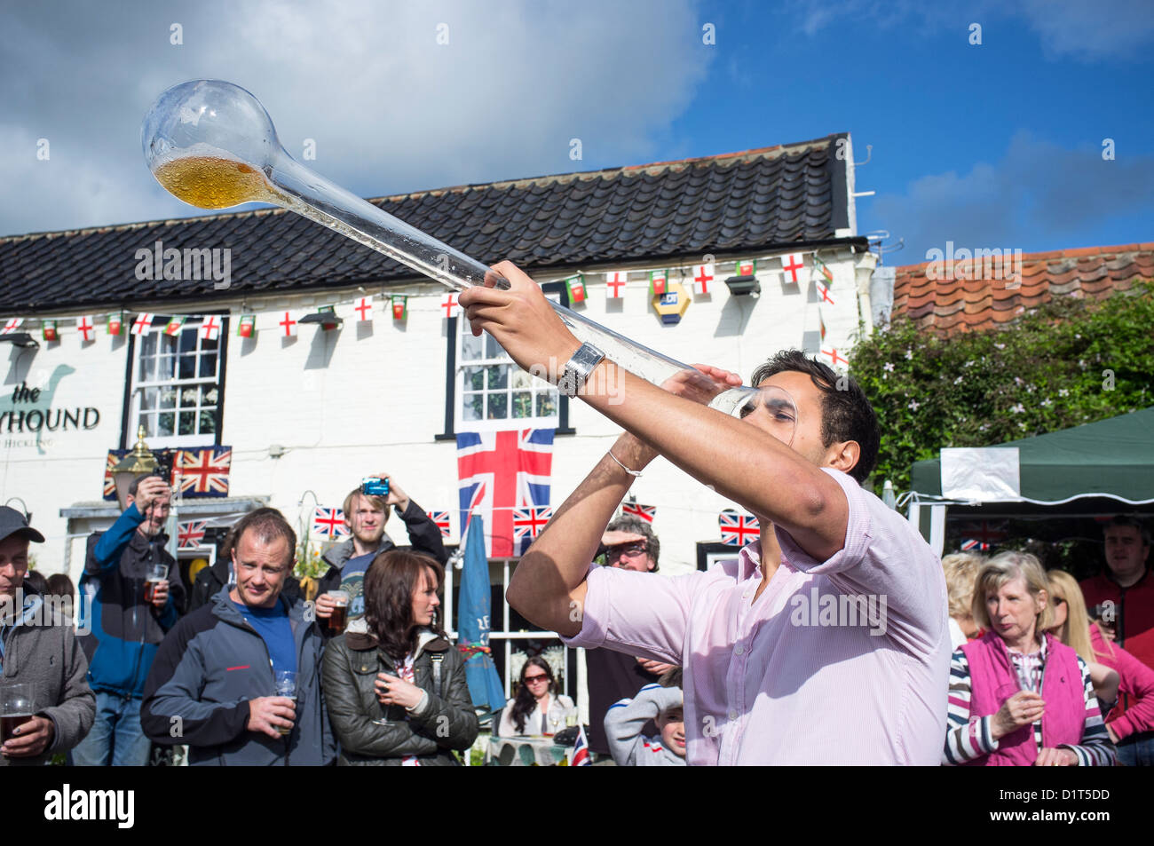 Junger Mann trinken Yard Of Ale im Dorfpub während Queen es Diamond Jubille feiern Stockfoto