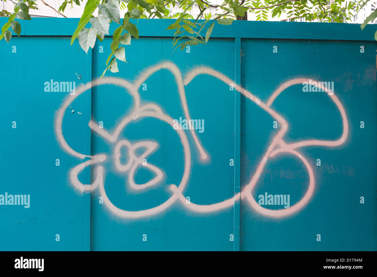 weiße Graffiti auf Türkis Horten mit Blättern hängen oben Stockfoto