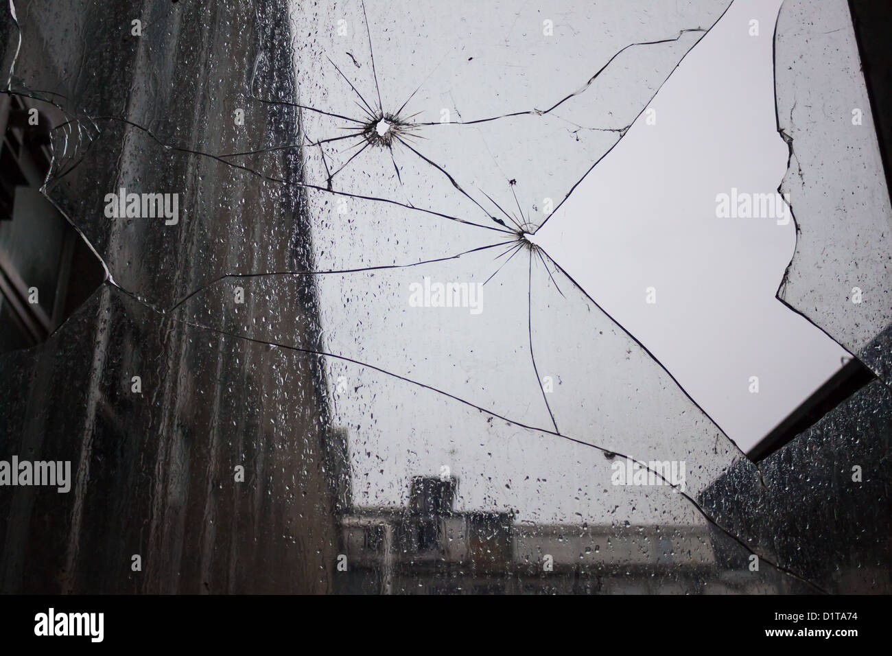 zerbrochene Fensterscheiben mit Regentropfen Stockfoto