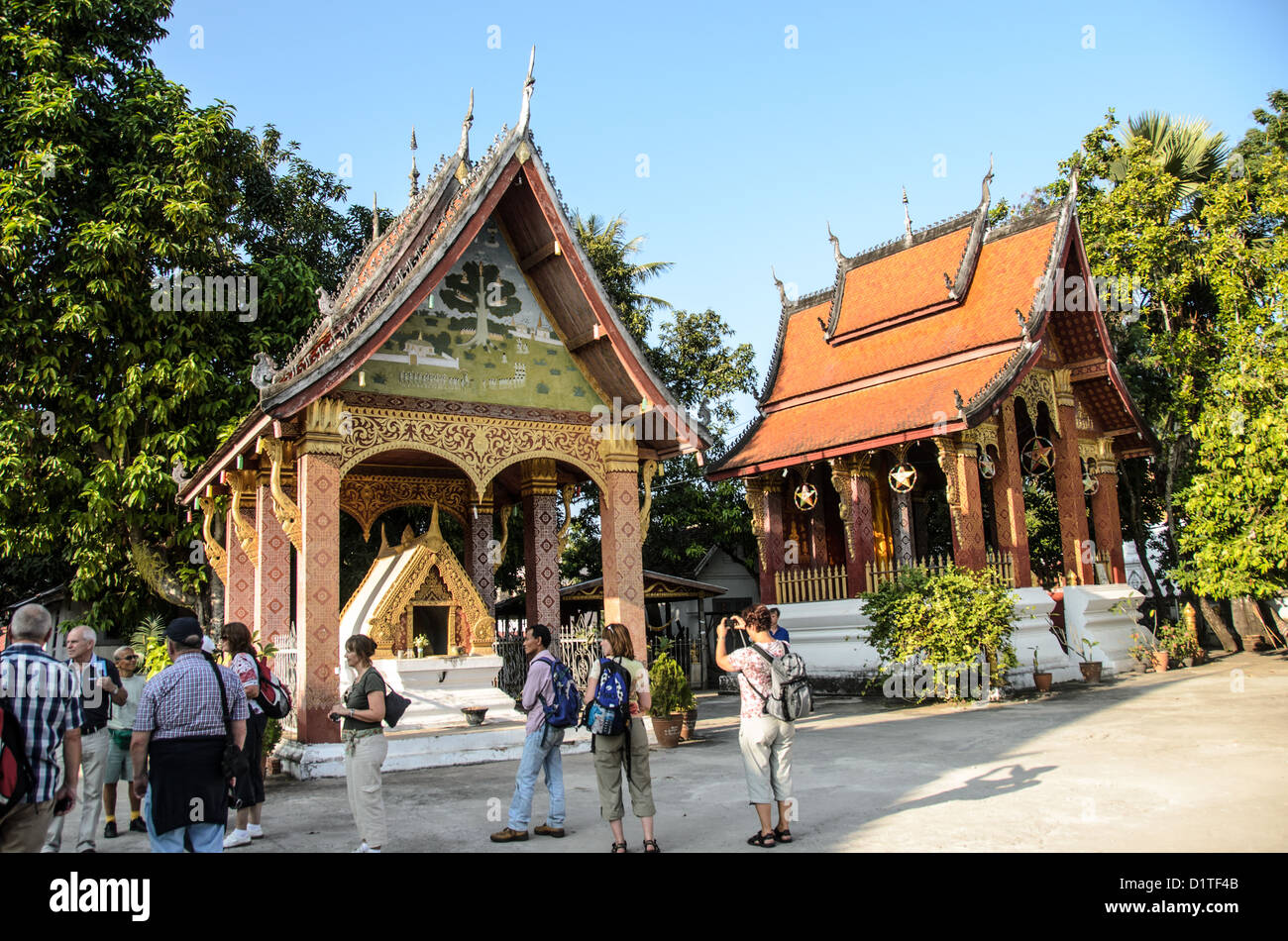Wat Sensoukharam buddhistischer Tempel Luang Prabang Laos // LUANG PRABANG, Laos — Eine Gruppe von Touristen besucht Wat Sensoukharam, einen buddhistischen Tempelkomplex mit zwei Pagodenstrukturen. Wat Sensoukharam gehört zu den zahlreichen Tempeln, die Luang Prabang zum UNESCO-Weltkulturerbe erklärt haben. Der Tempelkomplex repräsentiert die traditionelle laotische buddhistische Architektur, die im gesamten historischen Stadtzentrum zu finden ist. Luang Prabang diente als königliche Hauptstadt des Königreichs Laos und gilt weithin als eine der am besten erhaltenen kolonialen und vorkolonialen städtischen Siedlungen Südostasiens Stockfoto