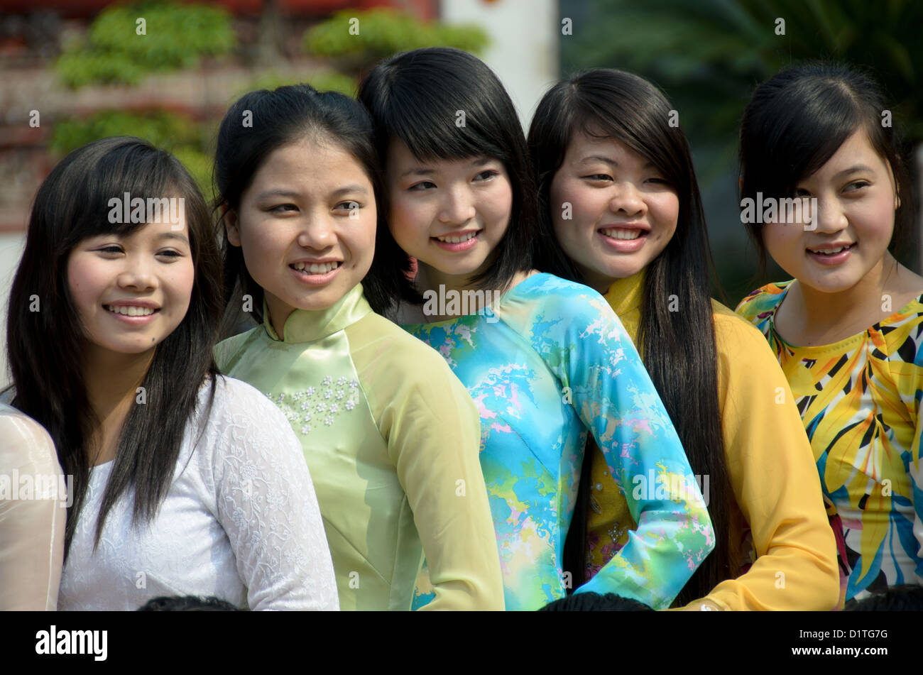 HANOI, Vietnam – Eine Gruppe junger vietnamesischer Frauen in traditioneller Kleidung posiert für Fotos, während sie den Tempel der Literatur in Hanoi besuchen. Der Tempel wurde 1070 erbaut und ist einer von mehreren Tempeln in Vietnam, die Konfuzius, Weisen und Gelehrten gewidmet sind. Stockfoto