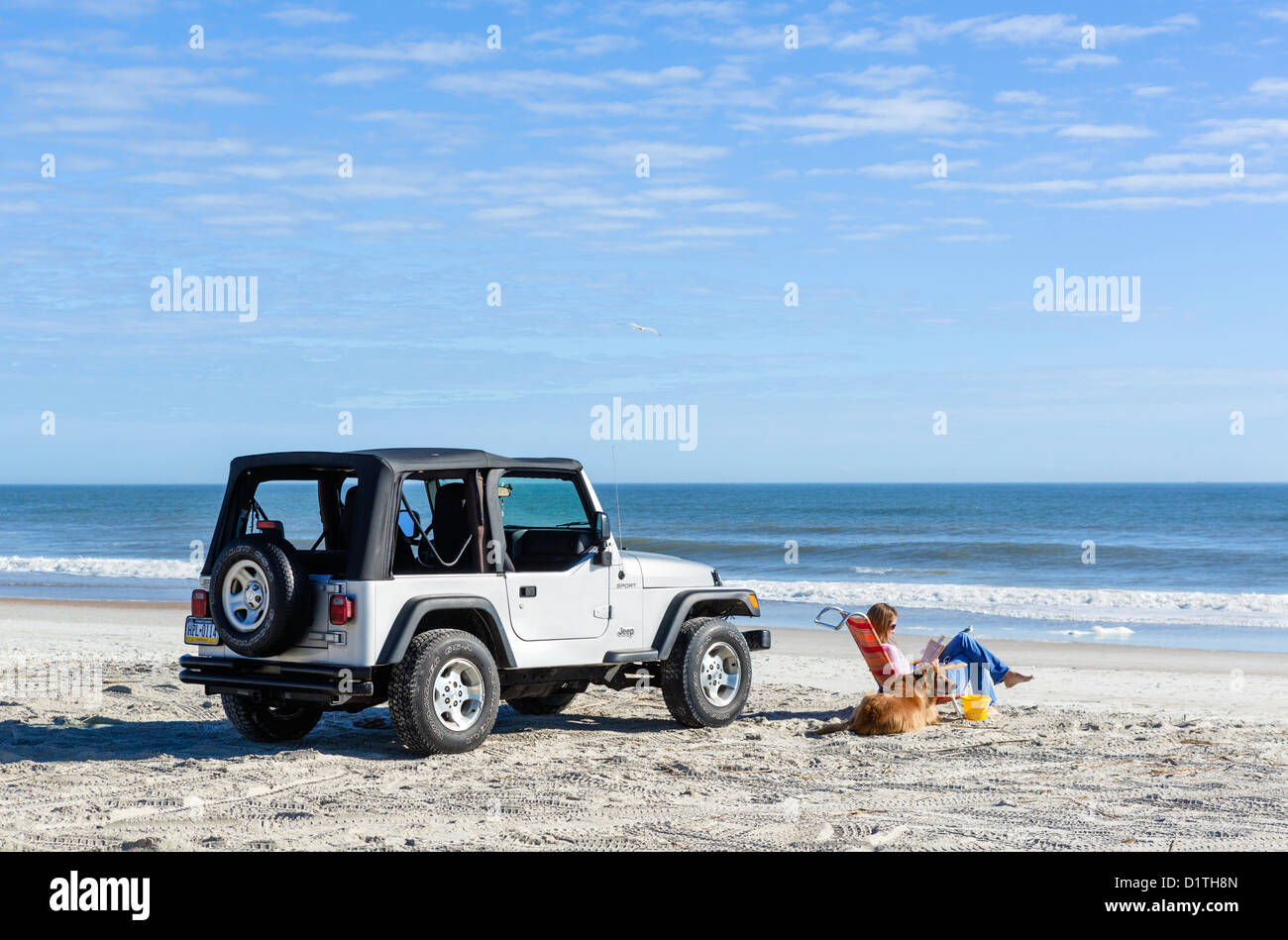 Junge Frau und ihr Hund sitzen ein Jeep Wrangler, Seaside Park Beach, Fernandina Beach, Amelia Island, Florida, USA Stockfoto