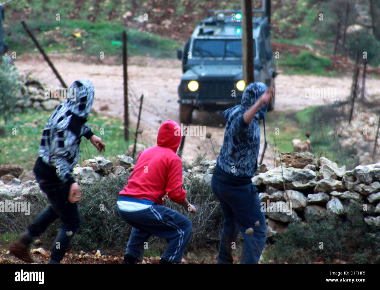 5. Januar 2013 - Nablus, West Bank, Palästina - palästinensische Demonstranten mit Steinen werfen gegen die israelischen Sicherheitskräfte während der Zusammenstöße in den nördlichen Dorf Qusra, südlich von der Stadt Nablus im israelischen besetzten Westjordanland, nachdem jüdische Siedler aus den nahe gelegenen Esh Kodesh Außenposten die Abdeckung des Nebels zu Ansatz Qusra mit dem Ziel der Entwurzelung Dutzende von Olivenbäumen Setzlinge verwendet , aber von palästinensischen Bauern konfrontiert wurden, die Steinen sie, am 5. Januar 2013 warf (Credit-Bild: © Nedal Eshtayah/APA Images/ZUMAPRESS.com) Stockfoto