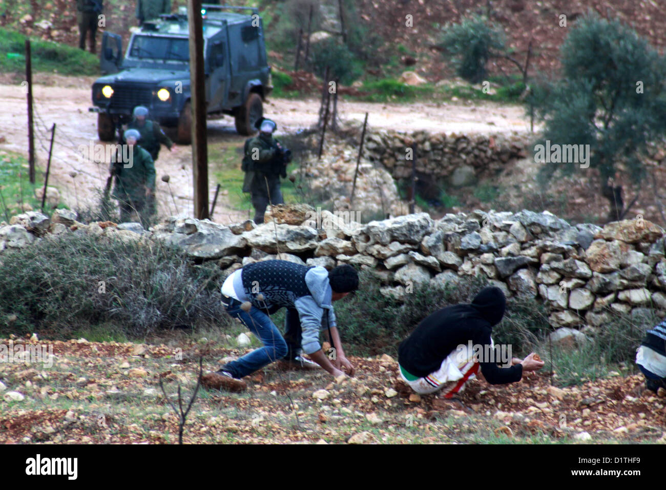 5. Januar 2013 - Nablus, West Bank, Palästina - palästinensische Demonstranten mit Steinen werfen gegen die israelischen Sicherheitskräfte während der Zusammenstöße in den nördlichen Dorf Qusra, südlich von der Stadt Nablus im israelischen besetzten Westjordanland, nachdem jüdische Siedler aus den nahe gelegenen Esh Kodesh Außenposten die Abdeckung des Nebels zu Ansatz Qusra mit dem Ziel der Entwurzelung Dutzende von Olivenbäumen Setzlinge verwendet , aber von palästinensischen Bauern konfrontiert wurden, die Steinen sie, am 5. Januar 2013 warf (Credit-Bild: © Nedal Eshtayah/APA Images/ZUMAPRESS.com) Stockfoto