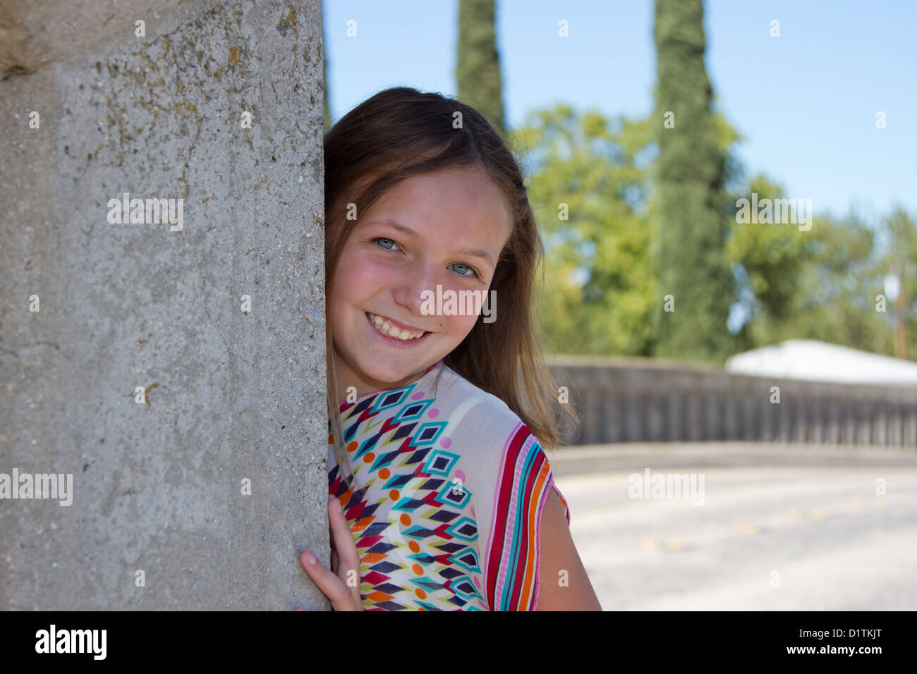 Eine junger Pre Teenie kaukasische Mädchen Modellierung der 1960er Jahre Stil Krawatte gefärbte Kleidung. Sie hat blaue Augen und eine spielerische warmes Lächeln. Sie ist weari Stockfoto