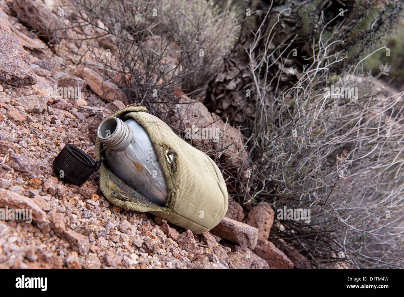 In einer trockenen, abgelegenen Wildnis der Wüste sitzt eine leere militärische Kantine vor trockenen Pinsel Stockfoto