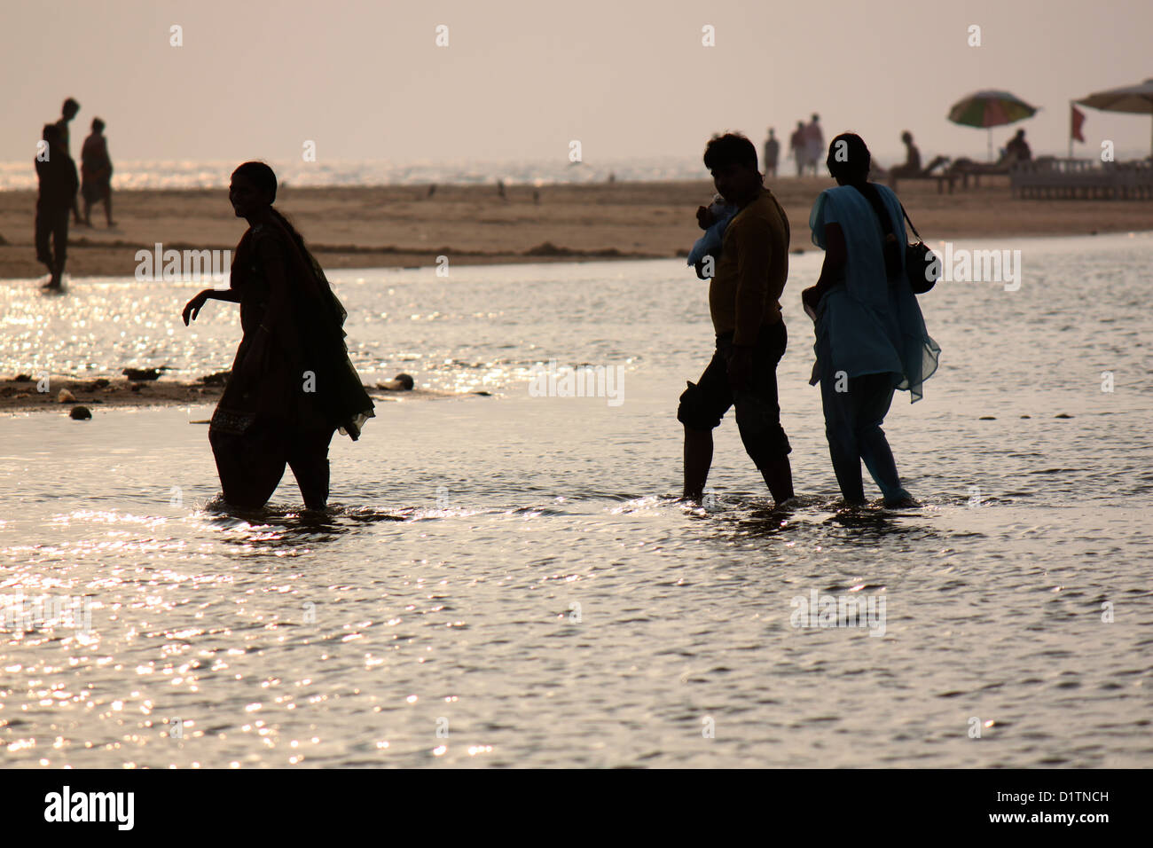 Familien am Strand von Trivandrum, Kerala, Indien bei Sonnenuntergang paddeln Stockfoto
