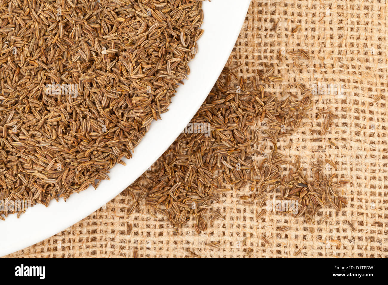 Kümmel / Kreuzkümmel Samen auf Platte über Jute-Stoff Stockfoto
