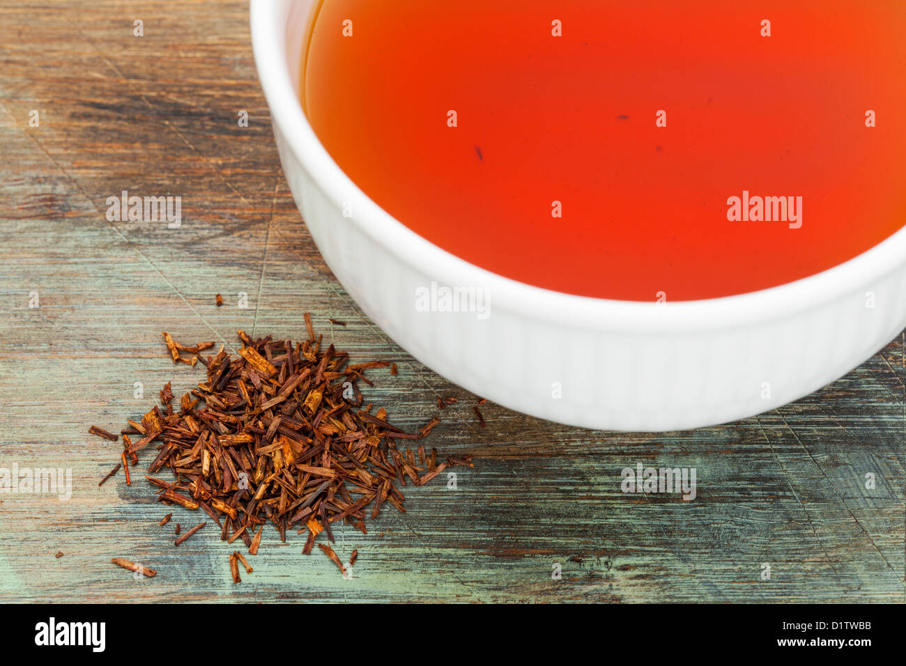 Rooibos-roter Tee - Blätter eine weiße Tasse trinken und lose auf Holz Hintergrund, Tee aus der südafrikanischen roten Busch Stockfoto