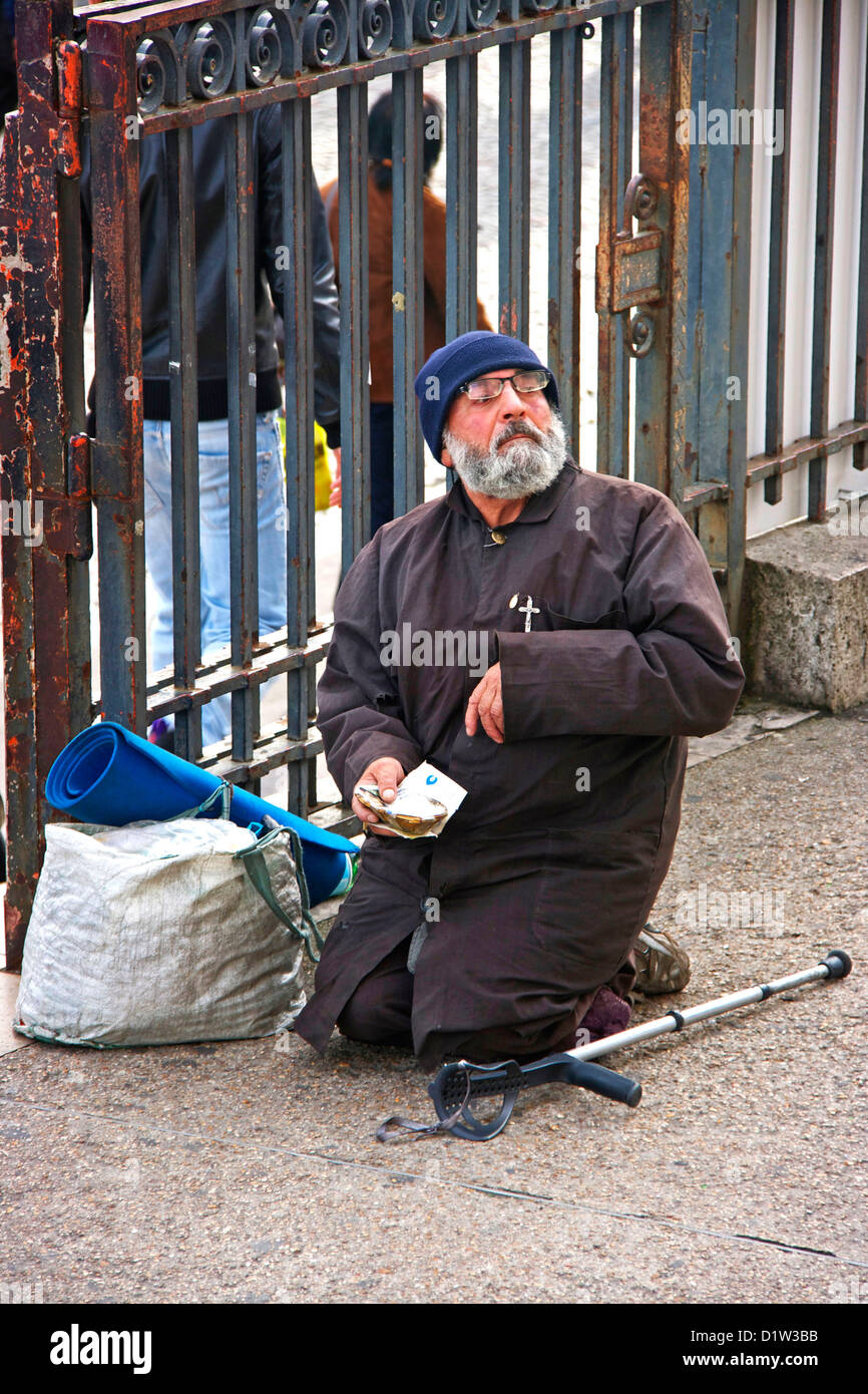 Eine sehbehinderte behinderte Bettler Mann durch Eingang der Sacre Coeur Paris Frankreich Europa kniend Stockfoto
